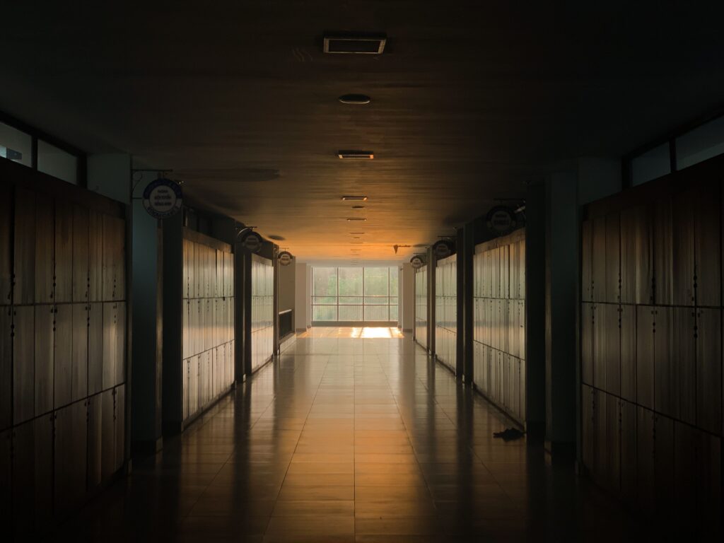 Peaceful school corridor at sunset with lockers and soft lighting.