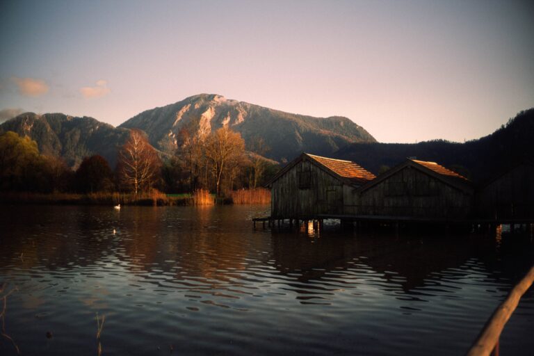 Serene lakeside cabins with mountain views at sunset, perfect for peaceful retreats.
